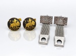 BIJUTERIAS, quatro (4) abotoaduras, sendo dois pares: A) um par redondo de Toledo em metal dourado, com fundo escuro e cena equestre em relevo e B) um par em metal prateado, de formato retangular, com decoração geométrica, motivo estrelado e fecho articulado em malha metálica. Peças apresentando sinais de uso.