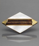 BIJUTERIA, um (1) broche no formato losangular, confeccionado em metal dourado, decorado com placas de galalite e faixas centrais em tons de marrom, com acabamento metálico trabalhado nas bordas, faltando 1 no lado esquerdo. Peça apresenta sinais de uso e falhas na douração, medindo 4x7cm.