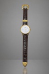 RELÓGIO, um (1) relógio de pulso da marca SUPERATIC, movimento quartz, caixa em metal dourado, mostrador claro com decoração representando tucano e ponteiros dourados. Pulseira em couro marrom texturizado, com fivela, passador e terminal em metal dourado ornamentado com motivos florais em relevo. Tampa traseira em aço, com etiqueta antiga de procedência. Leves sinais de uso, não testado e sem garantia de funcionamento, caixa medindo 4cm.