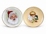 PORCELANAS, dois (2) pequenos pratos decorativos confeccionados em porcelana na tonalidade branca, assinados LAURA, sendo 1 decorado por Papai Noel em policromia com borda filetada a ouro e 1 representando figura angelical com pássaro sobre fundo creme, borda filetada a ouro. Ambos medindo 15,5cm.