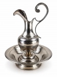METAL PRATEADO, duas (2) peças, sendo 1 bacia e 1 gomil, confeccionados em metal espessurado a prata, jarra com corpo torneado e bojudo, alça em voluta e borda recortada, base circular escalonada, medindo 40x23,5x9,5cm e bacia 9,5x33,5cm. Falhas no banho.