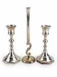 METAL PRATEADO, três (3) peças confeccionadas em metal espessurado a prata, sendo: A) 1 par de castiçais com corpo torneado, apoiada sobre base oitavada, medindo 14cm e B) 1 solifleur, corpo cilíndrico, com parte inferior em arabesco, apoiada sobre base circular, medindo 20,5cm.  Castiçais com banho novo.