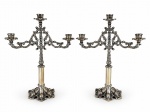 METAL PRATEADO, par (2) de candelabro para três velas confeccionados em metal espessurado a prata, coluna em caneluras, hastes em elementos vegetalistas em vazados, bobeche no feitio de flor, apoiada sobre base circular em recortes, medindo 39x31cm.