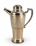 METAL PRATEADO, uma (1) coqueteleira confeccionada em metal espessurado a prata da manufatura ART PRATA, cinzelado por elementos florais e vegetalistas, alça em arabesco cinzelado por folhagens, banho novo, porém, necessita limpeza, medindo 23x19x10cm.