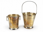 METAL PRATEADO, dois (2) baldes para gelo confeccionados em metal espessurado a prata, sendo: A) BELLINI, um (1) liso, cinzelado por elementos florais e vegetalistas em relevo com alças laterais em argola, medindo 13,5x11,5cm e B) ART PRATA, um (1) cinzelado por elementos vegetalistas em vazados, borda em recortes e alça central articulável, medindo 15,5x15cm. Ambas peças com banho novo, porém, necessitam limpeza.