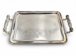 METAL PRATEADO, uma (1) bandeja retangular confeccionada em metal espessurado a prata, fundo com cinzelado vegetalista, bordas com canelura em relevo e alças laterais torneadas em vazados, banho novo, porém, necessita limpeza, medindo 40x25,5cm.