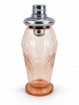 VIDRO, uma (1) coqueteleira confeccionada em vidro na tonalidade rosa, lapidado por palmas e elementos geométricos em baixo relevo, tampa em metal cromado com sinais de oxidação, pequeno bicado na borda, medindo 23cm.