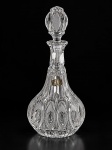 VIDRO, uma (1) licoreira confeccionada em vidro translúcido com moldagem em pingos de diamante, caneluras e formas ovais, fundo estrelado, apresenta quebra na tampa e selo com desgastes colado, medindo 31,5cm de altura.