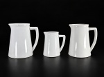 PORCELANA PII, três (3) leiteiras confeccionadas em porcelana na tonalidade branca, 2 maiores apresentam bicados e fios de cabelo, medindo 17x15x9cm e menor 13x12x7cm.