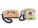 COLECIONISMO, dois (2) telefones de mesa vintage, sendo: A) aparelho em tom salmão, com teclado numérico de teclas e identificação, medindo 11x21,5x10cm e B) aparelho em tom marfim, com disco giratório, visor frontal de numeração e monofone correspondente, medindo 10x22x20cm. Ambos com cabos espiralados, apresentando sinais de uso, riscos, manchas e desgastes compatíveis com a idade. Funcionamento não testado. Peças no estado.