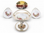 PORCELANAS, cinco (5) peças confeccionadas em porcelana de modelos, tamanhos e decorações distintas, sendo 1 travessa decorativa pintada a mão com bicado na borda, medindo 9,5x14cm, 1 cesta com alça sintética, medindo 13x18,5x14cm, 1 prato decorativo, medindo 11cm e 2 petisqueiras em formato de concha com pintura floral da marca C.T. ALTWASSER, medindo 12x10,5cm. No estado da foto.