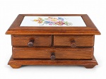 DIVERSOS, uma (1) caixa porta joias no feitio de comoda, confeccionada em madeira com tampo em azulejo com pintura floral em policromia, assinado Laura 93, apresenta bicado, 2 gavetas e 1 gavetão com interior em tecido aveludado na cor vermelha, medindo 9,5x20x12,5cm.
