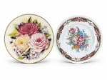 PORCELANAS, dois (2) pratos decorativos confeccionados em porcelana na tonalidade branca, sendo: A) T. LIMOGES, 1 decorado por guirlanda e elementos florais em policromia sobre fundo dourado e na tonalidade roxa, medindo 25,5cm e B) JSB, 1 decorado por flores e folhagens em policromia e borda filetada a ouro com falhas na douração, medindo 27cm.