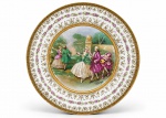 PORCELANA S, um (1) prato decorativo confeccionado em porcelana na tonalidade branca. decorada por guirlanda floral em policromia e douração, borda filetada a dourada decorada por elementos geométricos, centro representando cena galante em policromia, apresentando falhas na douração e na pintura, medindo 24,5cm.