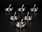 METAL PRATEADO, seis (6) taças para sobremesa com suas respectivas colheres confeccionadas em metal espessurado a prata, bojo liso, apoiado sobre 3 pés em bola, alça vazada cinzelada por folhagens, banho novo, medindo 3,5x11x8,5cm.