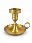 BRONZE, um (1) castiçal palmatória confeccionado em bronze, corpo torneado e bobeche circular com alça lateral vazada, medindo 10x12x9cm.