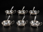 METAL PRATEADO, seis (6) taças para sobremesa confeccionadas em metal espessurado a prata  com colheres adaptadas da manufatura EBERLE, corpo liso, alça cinzelada por folhagens, apoiadas sobre 3 pés curvos, banho novo, medindo 4x12x8,5cm.