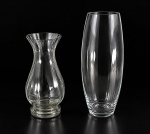 VIDROS, dois (2) vasos confeccionados em vidro translucido, sendo: A) 1 corpo balaustre, corpo canelado, bicado na borda, medindo 29,5x11,5cm e B) 1 liso com corpo bojudo, medindo 37,5x10cm.