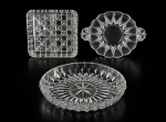VIDROS, lote com três (3) peças confeccionadas em vidro translucido, sendo: A) 1 travessa oval e funda com moldagem geométrica com fundo estrelado, medindo 5x27,5x21cm, B) 1 bandeja redonda com moldagem geométrica com alças em elementos vazados, medindo 23x18cm e C) 1 petisqueira com 3 divisórias com moldagem quadrangular com estrelas, medindo 18,5x18,5cm.