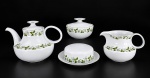 PORCELANAS RENNER - Conjunto para chá, composto por quatro (4) peças, sendo: um (1) bule com tampa , med : 18 cm , uma (1) leiteira , med : 12 cm , apresenta bicado na borda, um (1) açucareiro com tampa  , med : 11 cm  e uma (1) manteigueira , med : 7 x 18 cm . Em porcelana branca, com decoração de ramos e folhagens verdes em policromia e delicados filetes nas bordas.