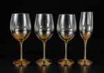 CRISTAIS, conjunto composto por quatro (4) taças, sendo três (3) para vinho e uma (1) para espumante, em vidro translúcido fumê, com tonalidade âmbar dourada na parte inferior dos bojos, hastes alongadas e bases circulares douradas. Medidas : 24 e 25 cm's