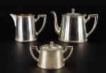 METAL PRATEADO, três (3) peças para chá confeccionados em metal espessurado a prata da manufatura WOLFF, cinzelado por caneluras, fitas cruzadas e rosinhas, sendo: A) 1 bule para chá, medindo 14,5x21x7,5cm, B) 1 açucareiro, medindo 9x16x6,5cm e C) 1 leiteira, medindo 11,5x15,5x7cm. Banho novo, necessitando limpeza.