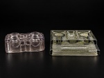 VIDROS, dois (2) tinteiros confeccionados em vidro, sendo: A) 1 na tonalidade rosa, moldada em caneluras, com dois recipientes sem tampa e 1 central, apresenta bicados, medindo 6,5x16x8cm e B) 1 em tom esverdeado com moldagem perolada, com dois compartimentos para tinta sem tampa, medindo 4,5x20x14,5cm.