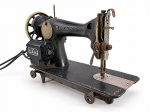 DIVERSOS, uma (1) máquina SINGER antiga, confeccionada em ferro fundido, com acabamento preto e filetes decorativos dourados, equipada com motor elétrico lateral, volante, conjunto de agulha e mecanismos aparentes. Apresenta sinais intensos de uso, oxidação, perdas no acabamento e desgastes compatíveis com a idade. Funcionamento não testado. Peça no estado, medindo 30x42x18cm.