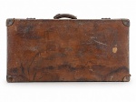 DIVERSOS, uma (1) antiga mala de viagem em couro marrom, formato retangular, com alça superior, ferragens metálicas, cantoneiras de proteção e iniciais A.S. gravadas na tampa. Interior revestido em tecido claro, com cintas internas para fixação de objetos. Apresenta intenso desgaste, riscos, manchas, perdas e sinais de uso compatíveis com a idade. Peça no estado. Medindo 39,5x76,5x24,5cm.