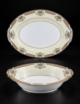PORCELANA NORITAKE, duas (2) travessas, sendo 1 oval e 1 funda confeccionadas em porcelana na tonalidade branca e creme, decorado por elementos florais e vegetalistas em rica policromia com filetes em ouro, maior medindo 42x31cm e menor 6x27x20,5cm.