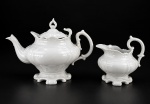 VISTA ALEGRE, duas (2) peças, sendo: A) 1 bule para chá, tampa não encaixa, medindo 18x26x16cm e B) 1 leiteira, medindo 14x14x12cm, confeccionados em porcelana portuguesa na tonalidade branca, decorada por gomos e elementos vegetalistas em recortes. Bule com pequena falha na esmaltagem.