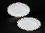 Sociedade de Porcelana de Coimbra (S.P. Coimbra), duas (2) travessas ovais confeccionadas em porcelana portuguesa na tonalidade branca, ricamente decorada por guirlanda floral, vegetalista e geométrica em policromia com filetes na cor verde, medindo 41x27,5cm e menor 28x19,5cm.