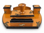 DIVERSOS, um (1) tinteiro confeccionado em madeira clara com arremates pretos e entalhes similando acabamento rústico, dois recipientes laterais com tampas com ausência do vidro, suporte frontal para correspondências/papéis, descanso para canetas, acompanha mata borrão sem forração, medindo 7,5x28x18cm.