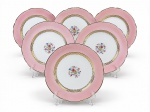 PORCELANA REAL, seis (6) pratos rasos confeccionados em porcelana na tonalidade branca com espessa faixa na tonalidade rosa, decorada por elementos florais em policromia e vegetalistas e filetes em ouro, medindo 23cm.