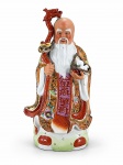 ESCULTURA ORIENTAL, uma (1) grande escultura confeccionada em porcelana na tonalidade branca representando sábio chinês, vestes ricamente decoradas por elementos florais em policromia com fundo avermelhado, realces em douração, apresenta bicados e colados, vendido no estado da foto, medindo 51cm de altura.