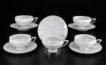 VISTA ALEGRE, cinco (5) xícaras para chá com seus respectivos pires confeccionados em porcelana portuguesa na tonalidade branca, bojo canelado, alça vazada, 1 pires apresentando bicado, medindo 5,5x12x9,5cm.