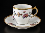 Gérard, Dufraisseix et Abbot (GDA) de Limoges, uma (1) xícara de coleção para café com seu respectivo pires, confeccionado em porcelana francesa na tonalidade branca, decorada por elementos florais e vegetalistas em policromia com filete em ouro, medindo 5,5x8x6cm.