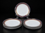PORCELANA REAL, nove (9) pratos fundos confeccionados em porcelana na tonalidade branca, decorada por faixas na tonalidade azul e vinho, guirlanda floral e filetes em ouro, medindo 22cm.