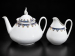 PORCELANA REAL, duas (2) peças para chá confeccionados em porcelana na tonalidade branca, decorada por guirlanda floral em ouro e faixa na tonalidade azul, sendo: A) 1 bule para chá, medindo 18x21,5cm e B) 1 leiteira, medindo 14x11cm.