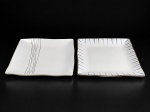 FAIANÇAS, duas (2) travessas quadrangulares confeccionadas em faiança vitrificada de linhas contemporâneas, sendo: A) branco, decorado com traços verticais e ondulados em preto e cinza, medindo 27x27cm e B) branco, com decoração geométrica na borda em tons de azul, bege e marrom, medindo 27x27cm bicado na borda.