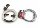 COLECIONISMO, dois (2) antigos cadeados ferradura para bicicleta, sendo: A) cadeado metálico com revestimento em tom cinza, mecanismo com chave e fecho articulado, apresentando forte oxidação e desgaste, medindo 15x13cm e B) cadeado cromado para bicicleta, marcado TAN-580, com detalhe esmaltado em vermelho e dourado, mecanismo de trava e suportes de fixação, medindo 15,5x12cm. Peças com sinais de uso, oxidação e desgaste. No estado.