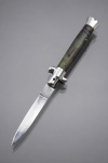CUTELARIA, um (1) canivete automático estilo Stiletto italiano, lâmina e arremates em aço, cabo com revestimento em madeira e sintético, um de cada lado, pinos metálicos, peça se encontra com a trava no estado, abre com pressão logo após o fechamento, medindo 21cm de comprimento.