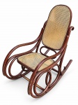 MOBILIÁRIO, uma (1) cadeira de balanço confeccionada em madeira com patina na tonalidade rouge de fer, assento e encosto em palinha natural com pequena falha no ínicio do espaldar, desgastes na patina e pequena voluta colada, medindo 108x115x54cm.