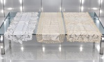 CAMA, MESA & BANHO, três (3) caminhos de mesa de modelos, tamanhos e decorações distintas, sendo 2 em tecido branco e 1 em tecido sintético, maior medindo 166x40cm e menor 95x50cm.