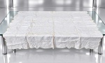 CAMA, MESA & BANHO, uma (1) toalha para chá confeccionada em linho branco com rica renda e bordado floral com recortes na borda, manchas de guardado, vide foto, apresenta pequenos furos, medindo 126x126cm.