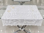 CAMA, MESA & BANHO, uma (1) toalha de mesa para chá quadrangular confeccionada em tecido na tonalidade branca, rico trabalho rendado de elementos florais e vegetalistas, apresenta furos e manchas, medindo 120x124cm.