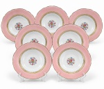 PORCELANA REAL, sete (7) pratos fundos confeccionados em porcelana na tonalidade branca com espessa faixa na tonalidade rosa, decorada por elementos florais em policromia e vegetalistas e filetes em ouro, medindo 23cm de diâmetro.