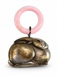 METAL PRATEADO, um (1) chocalho infantil antigo em formato de coelho, em metal espessurado a prata, com argola superior em material sintético na cor rosa. Apresenta sinais de uso e falhas na prateação, medindo 7x5cm.