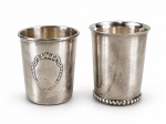 METAL PRATEADO, dois (2) copos infantis confeccionados em metal espessurado a prata, sendo: A) 1 cinzelado por brasão relevado, medindo 6,5x5,5cm e B) 1 com corpo liso e base em perolados, medindo 7x5,5cm.