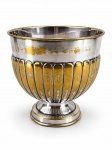 METAL PRATEADO, um (1) cachepot confeccionado em metal espessurado a prata, corpo em caneluras, haste cônica, apoiada sobre base circular escalonada, apresenta falhas na prateação e mossa na base, medindo 19x20,5cm.